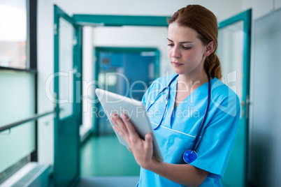 Surgeon using digital tablet in corridor