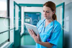 Surgeon using digital tablet in corridor