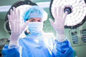 Portrait of female surgeon showing surgical gloves