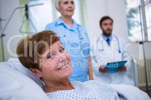 Portrait of smiling patient lying on bed