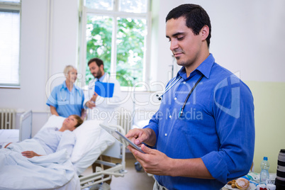 Confident doctor using digital tablet