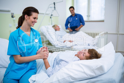 Nurse consoling a patient in hospital ward