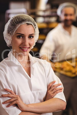 Portrait of female baker standing with arms crossed