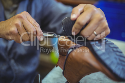 Shoemaker repairing a shoe sole
