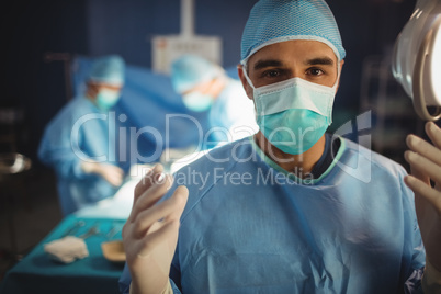Portrait of male surgeon preparing for operation in operation ro
