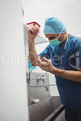 Male surgeon washing hands prior to operation using correct tech