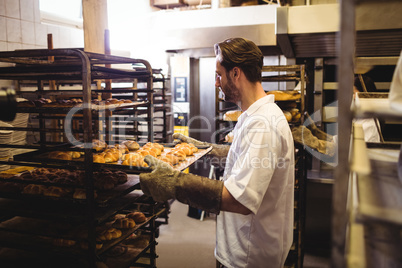 Male baker holding a tray of michetta