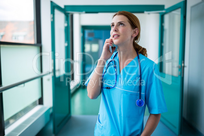 Surgeon talking on mobile phone in corridor