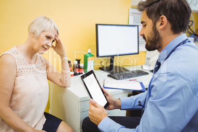 Doctor discussing with patient over digital tablet