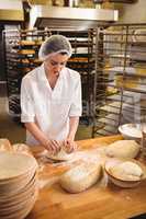 Female baker kneading a dough