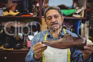 Shoemaker examining a shoe