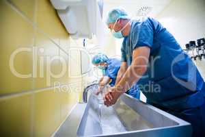 Group of surgeons washing their hands at washbasin