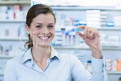 Pharmacist checking a capsule in pharmacy