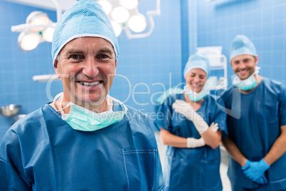 Portrait of surgeon and nurses smiling in operation room