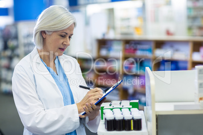 Pharmacist writing on clipboard