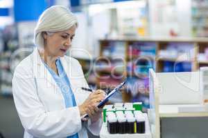 Pharmacist writing on clipboard