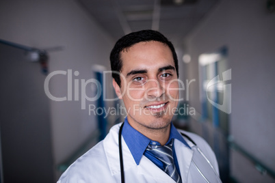 Confident doctor standing in hospital corridor