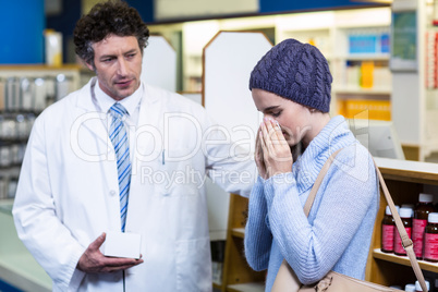 Pharmacist showing medicine to customer