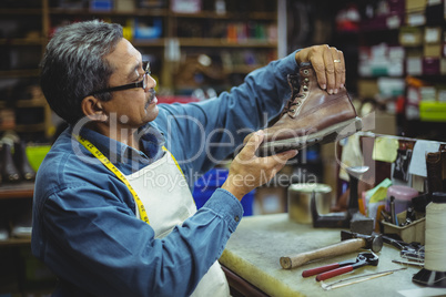 Shoemaker examining a shoe