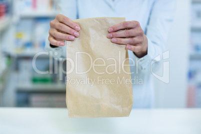 Pharmacist holding a medicine package in pharmacy