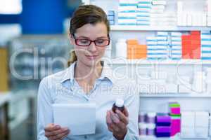 Pharmacist checking at prescription and medicine container