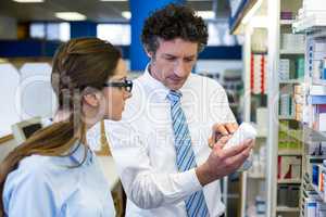 Pharmacists checking medicines on shelf in pharmacy