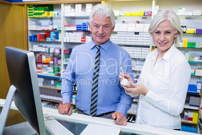 Smiling pharmacists standing in pharmacy