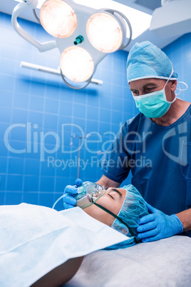 Surgeon placing an oxygen mask on the face of a patient