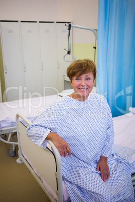 Portrait of smiling senior patient sitting on a bed