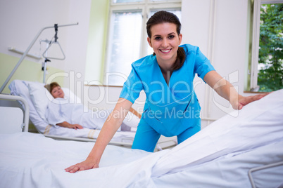 Nurse preparing a bed for a patient