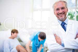 Smiling doctor standing with arms crossed