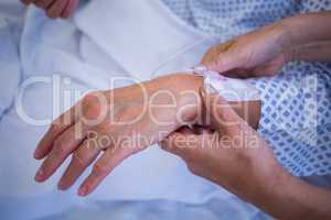 Nurse attaching iv drip on patient s hand