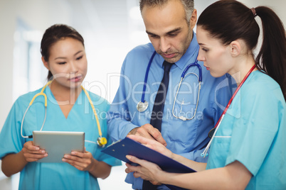 Doctor and nurses looking at clipboard