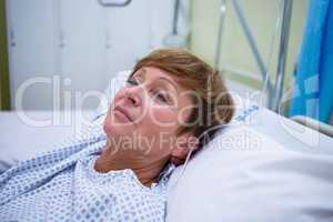 Sad senior patient lying on a bed