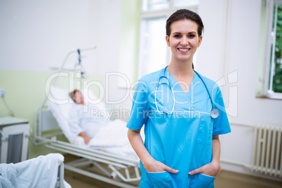 Smiling nurse standing with hands in pocket