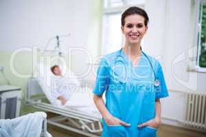 Smiling nurse standing with hands in pocket