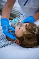 Nurse placing an oxygen mask on the face of a patient