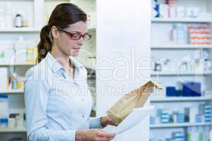 Pharmacist checking prescription and medicine package