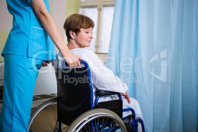 Patient sitting on wheel chair with nurse standing behind