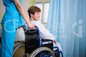 Patient sitting on wheel chair with nurse standing behind