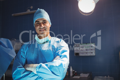 Portrait of surgeon standing with arms crossed in operation room