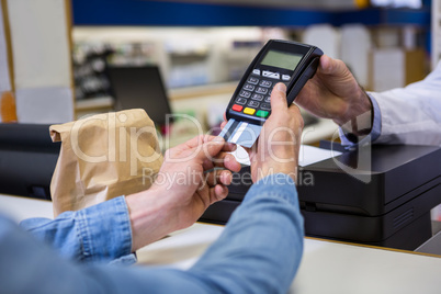 Customer entering pin in payment terminal machine