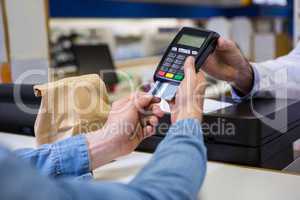 Customer entering pin in payment terminal machine