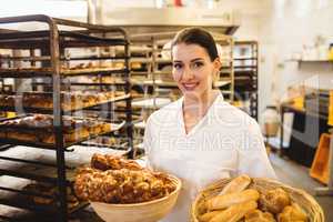 Female baker holding basket of sweet foods