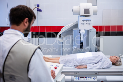 Doctor using x-ray machine to examine patient