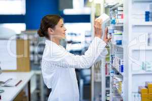 Pharmacist checking medicine in shelf