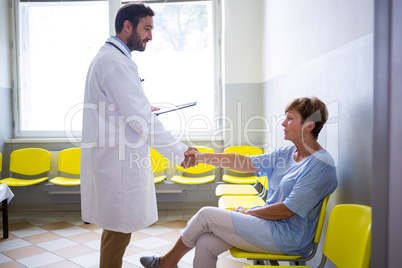 Doctor shaking hand with patient in waiting room