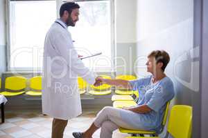 Doctor shaking hand with patient in waiting room