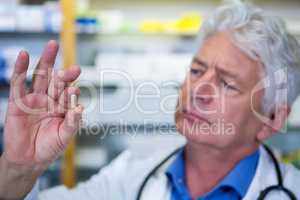 Pharmacist checking a capsule