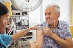 Female doctor giving an injection to a patient